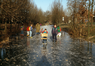 832899 Afbeelding van schaatsende kinderen op het bevroren water langs de St. Gotthard te Utrecht (Lunetten).